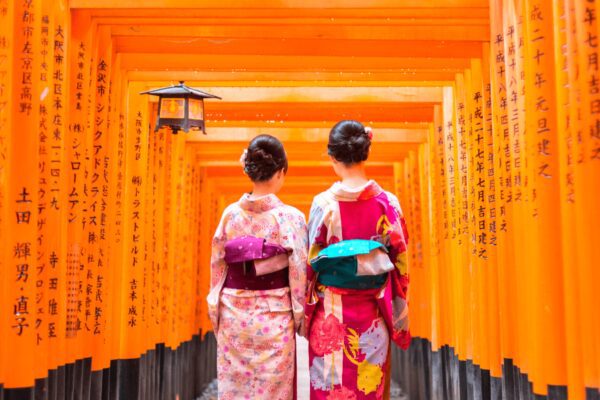 geishas en kimono rose à kyoto au Fushimi Inari Shrine sous un couloir de torii oranges