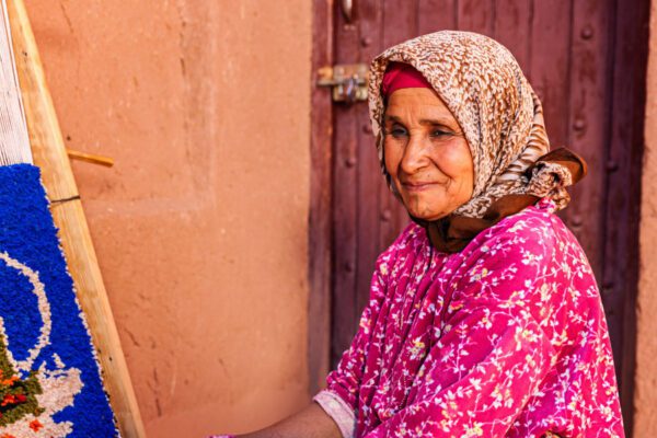 Femme marocaine en tenue traditionnelle rose dans un village berbère