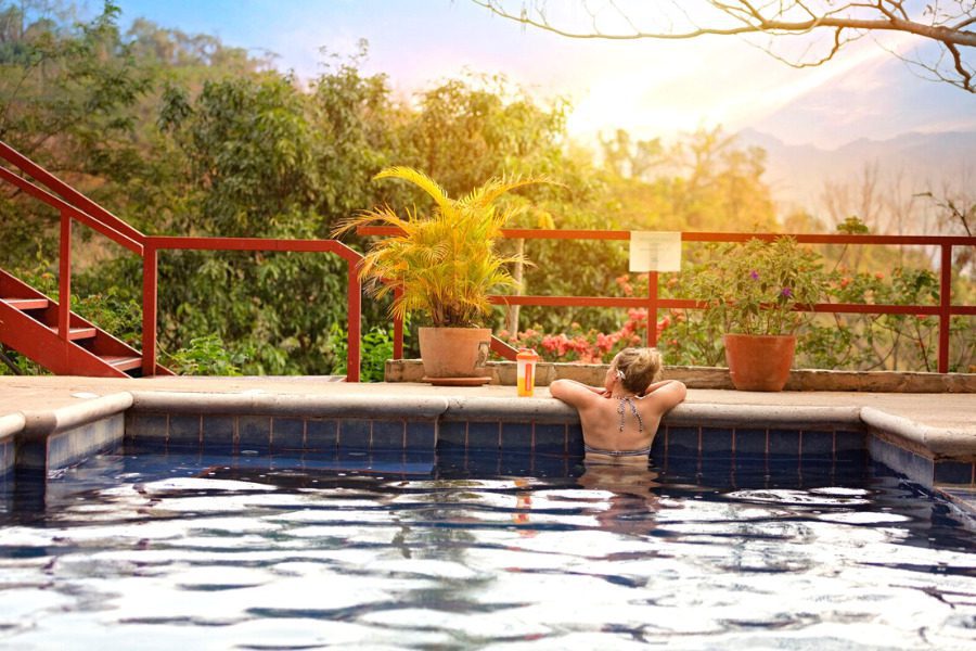 femme dans une piscine de dos regarde la jungle au Costa Rica
